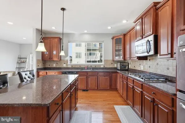 a kitchen with stainless steel appliances granite countertop a sink stove and cabinets