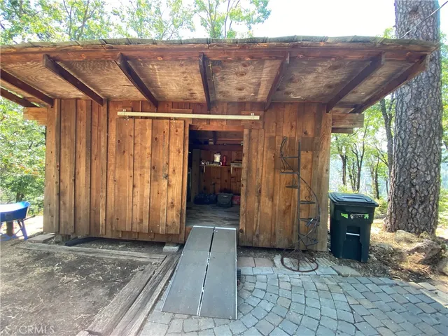 a backyard of a house with table and chairs under an umbrella