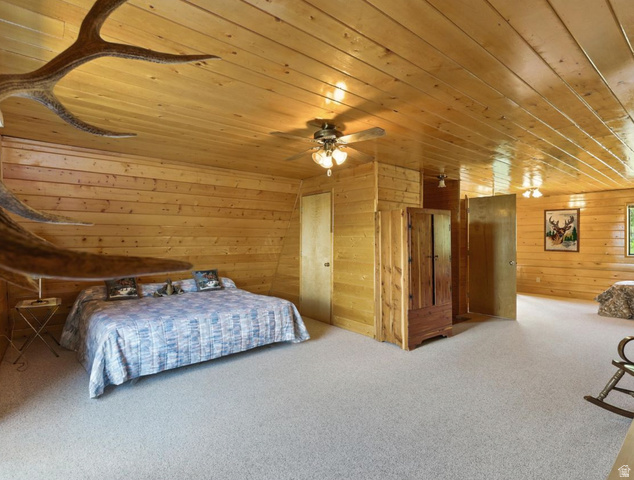 1180 Oak Road Coalville, UT 84017 - Photo 21 of 28 Wood-paneled walls and ceiling, ceiling fans, built-in wooden cabinetry, and neutral carpeting