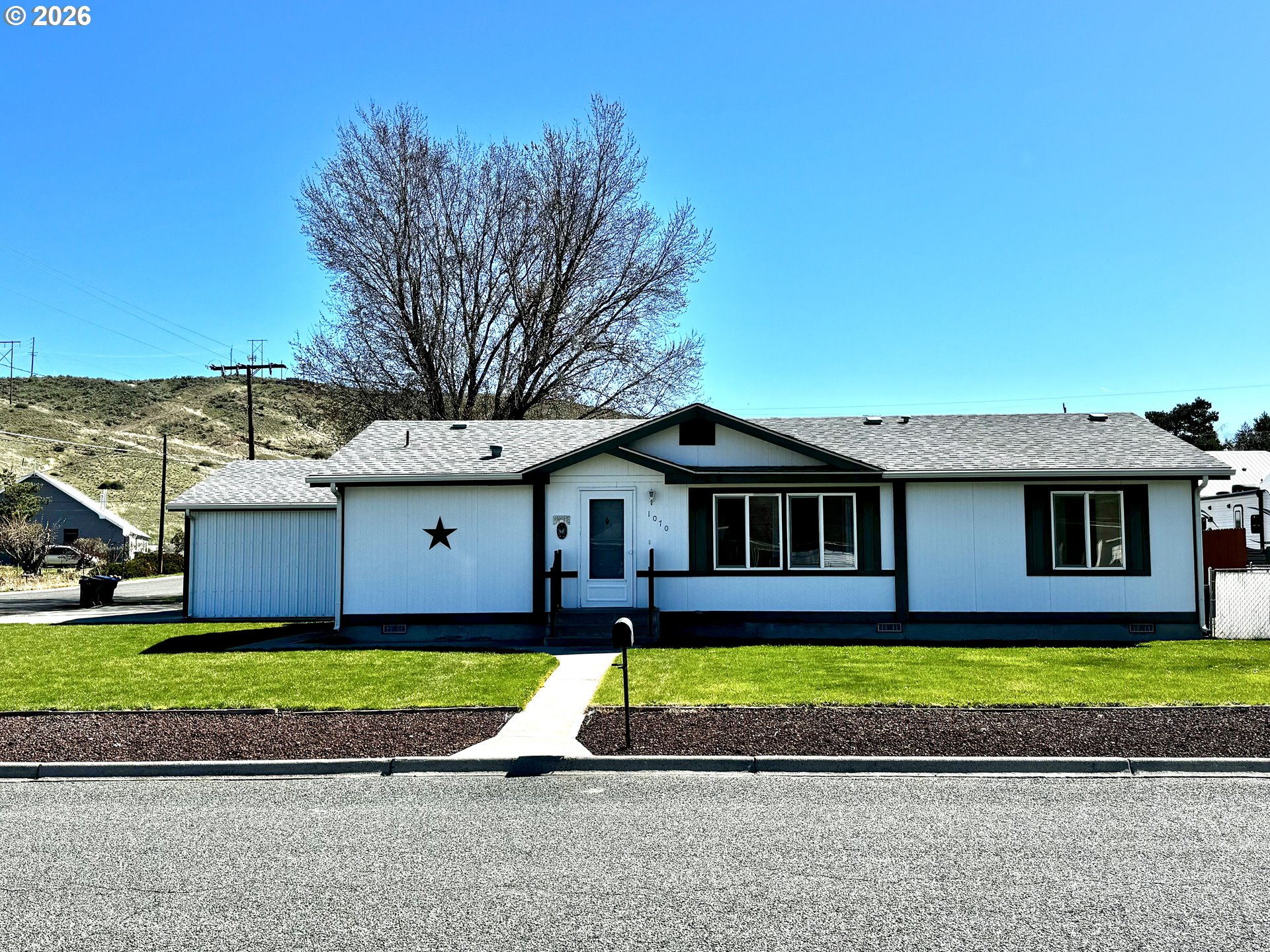 1070 Grove Street Baker City, OR 97814 - Photo 1 of 30 a view of a white house with a big yard and large trees