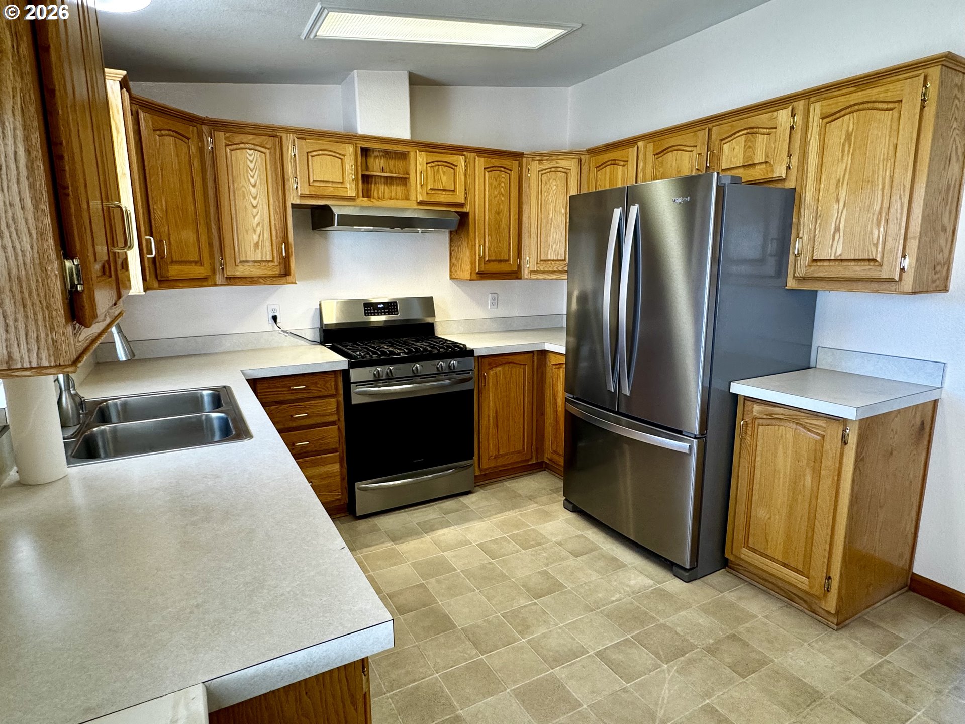 1070 Grove Street Baker City, OR 97814 - Photo 12 of 30 a kitchen with stainless steel appliances granite countertop a stove a sink and a refrigerator
