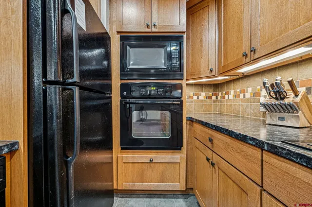 a kitchen with granite countertop a stove and a refrigerator