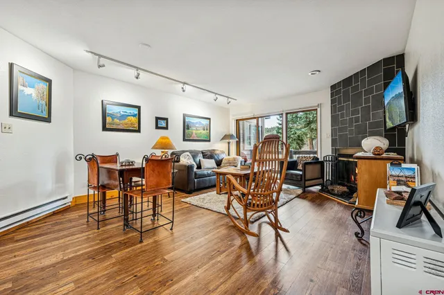 a living room with furniture and a flat screen tv with wooden floor