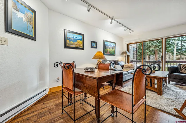a living room with furniture a large window and a wooden floor