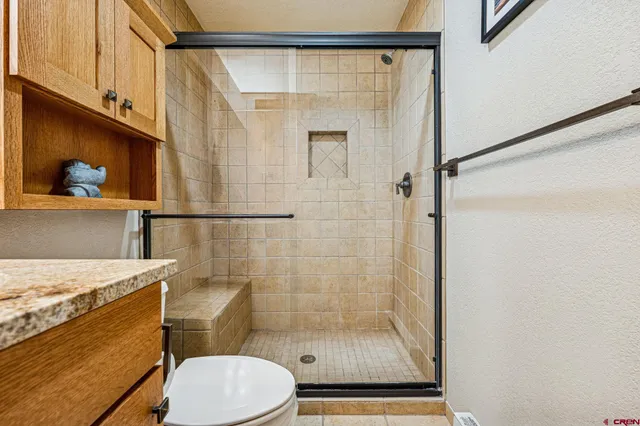 a bathroom with a shower a toilet and a sink