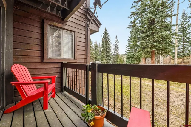 a balcony with wooden floor table and chairs