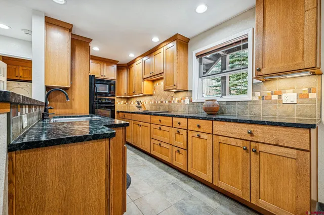 a kitchen with granite countertop a sink and a window