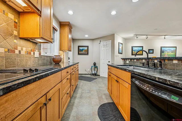 a large kitchen with stainless steel appliances a sink a stove and cabinets