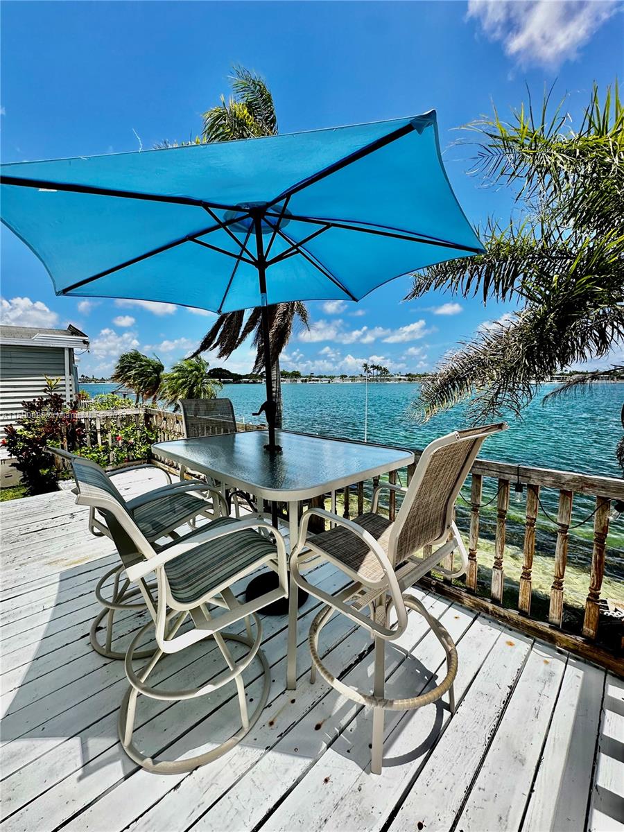 a roof deck with table and chairs under an umbrella