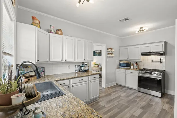 a kitchen with a sink appliances and cabinets