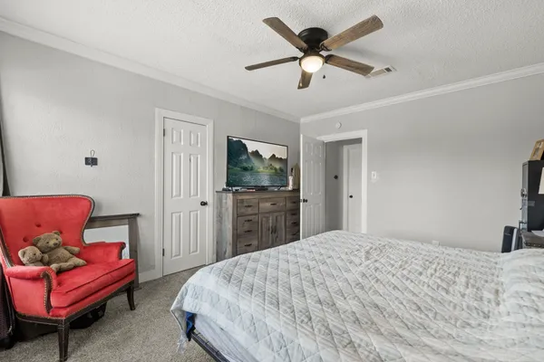 a bedroom with a bed a couch and a chandelier