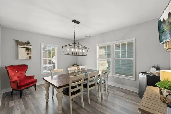 a view of a dining room with furniture a chandelier and wooden floor