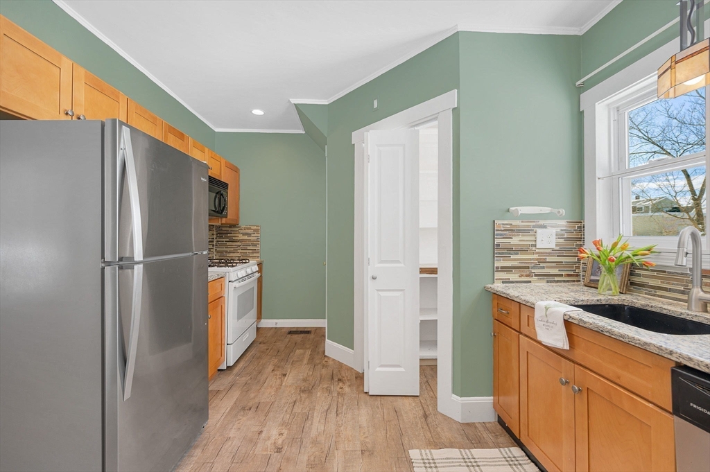 69 Ash Street Reading, MA 01867 - Photo 11 of 29 a kitchen with stainless steel appliances a refrigerator and a stove