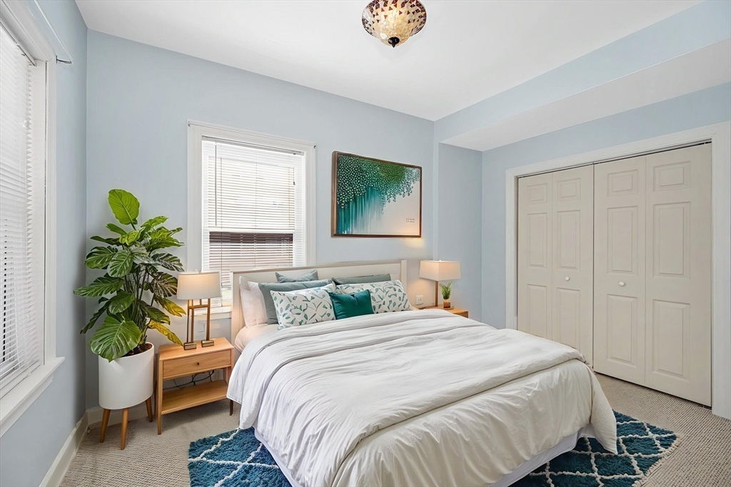 69 Ash Street Reading, MA 01867 - Photo 13 of 29 a bedroom with a bed potted plant and windows