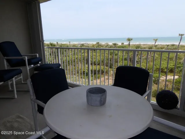 a view of a balcony with table and chairs