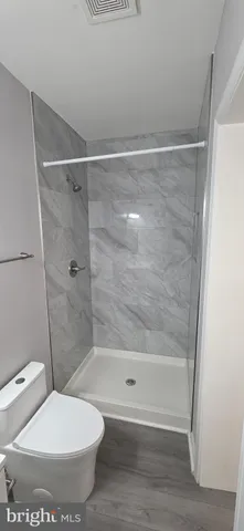 a bathroom with a toilet and a shower