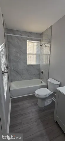 a bathroom with a toilet and a bath tub