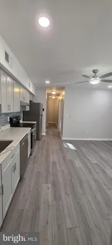 a large kitchen with stainless steel appliances a large counter top a sink and a stove