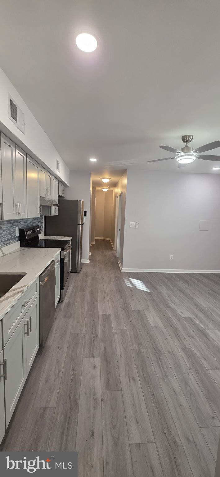 1400 Staples Street Northeast, Unit 1 Washington, DC 20002 - Photo 9 of 13 a large kitchen with stainless steel appliances a large counter top a sink and a stove