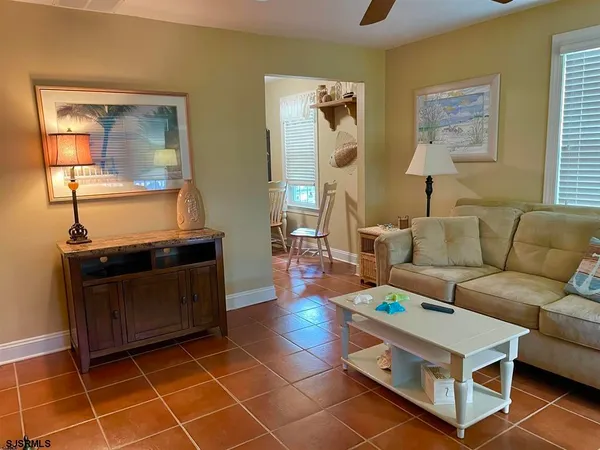 a living room with furniture a flat screen tv and a window