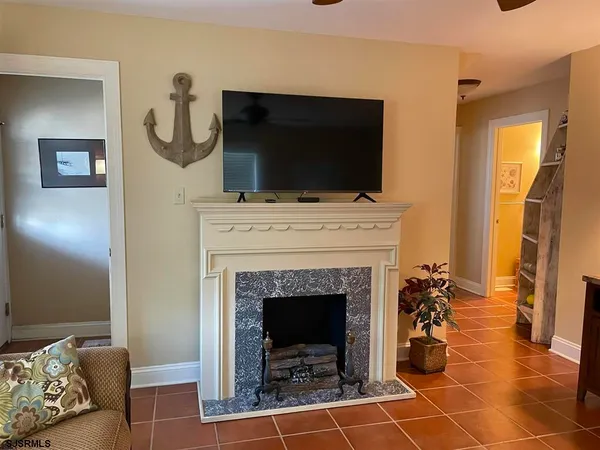 a living room with furniture a flat screen tv and a fireplace