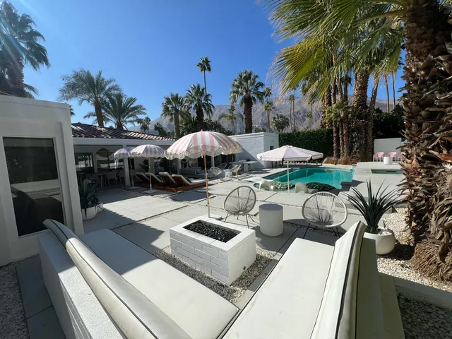 a living room with furniture a mirror and a wooden floor