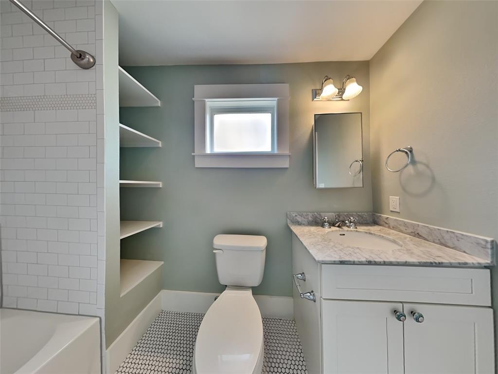 5536 Tremont Street Dallas, TX 75214 - Photo 13 of 21 a bathroom with a toilet sink and mirror