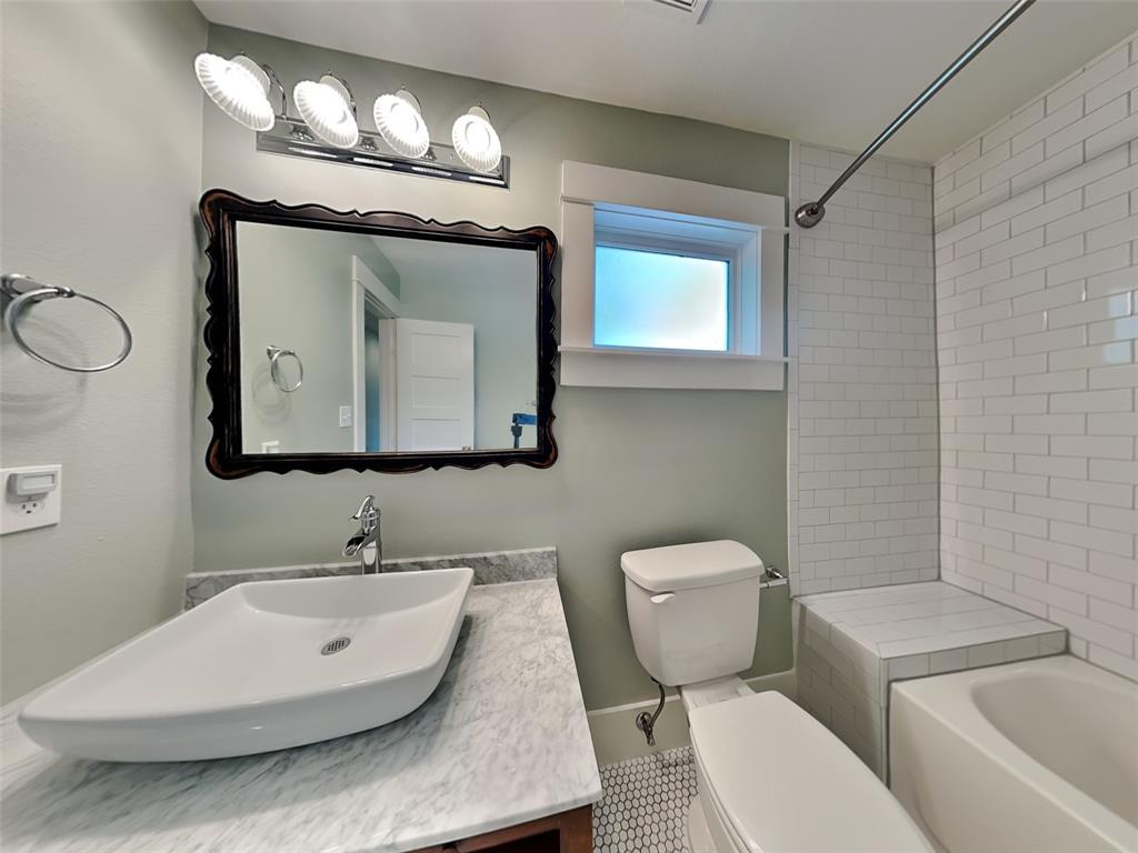 5536 Tremont Street Dallas, TX 75214 - Photo 17 of 21 a bathroom with a toilet sink and mirror