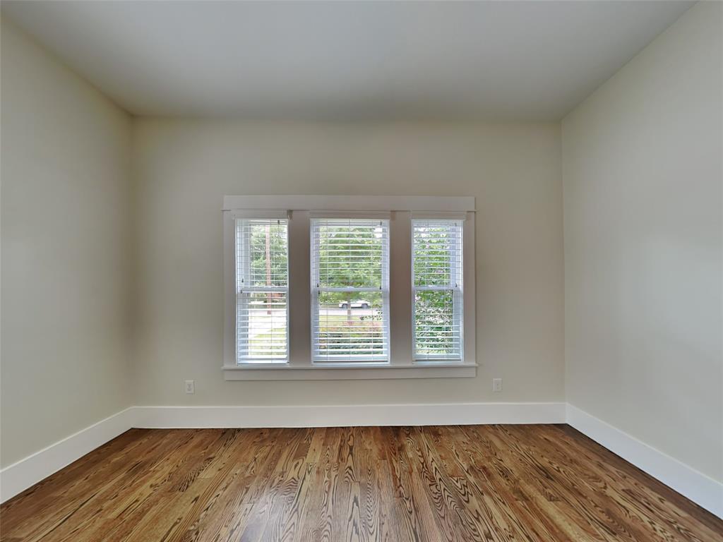 5536 Tremont Street Dallas, TX 75214 - Photo 3 of 21 an empty room with wooden floor and windows