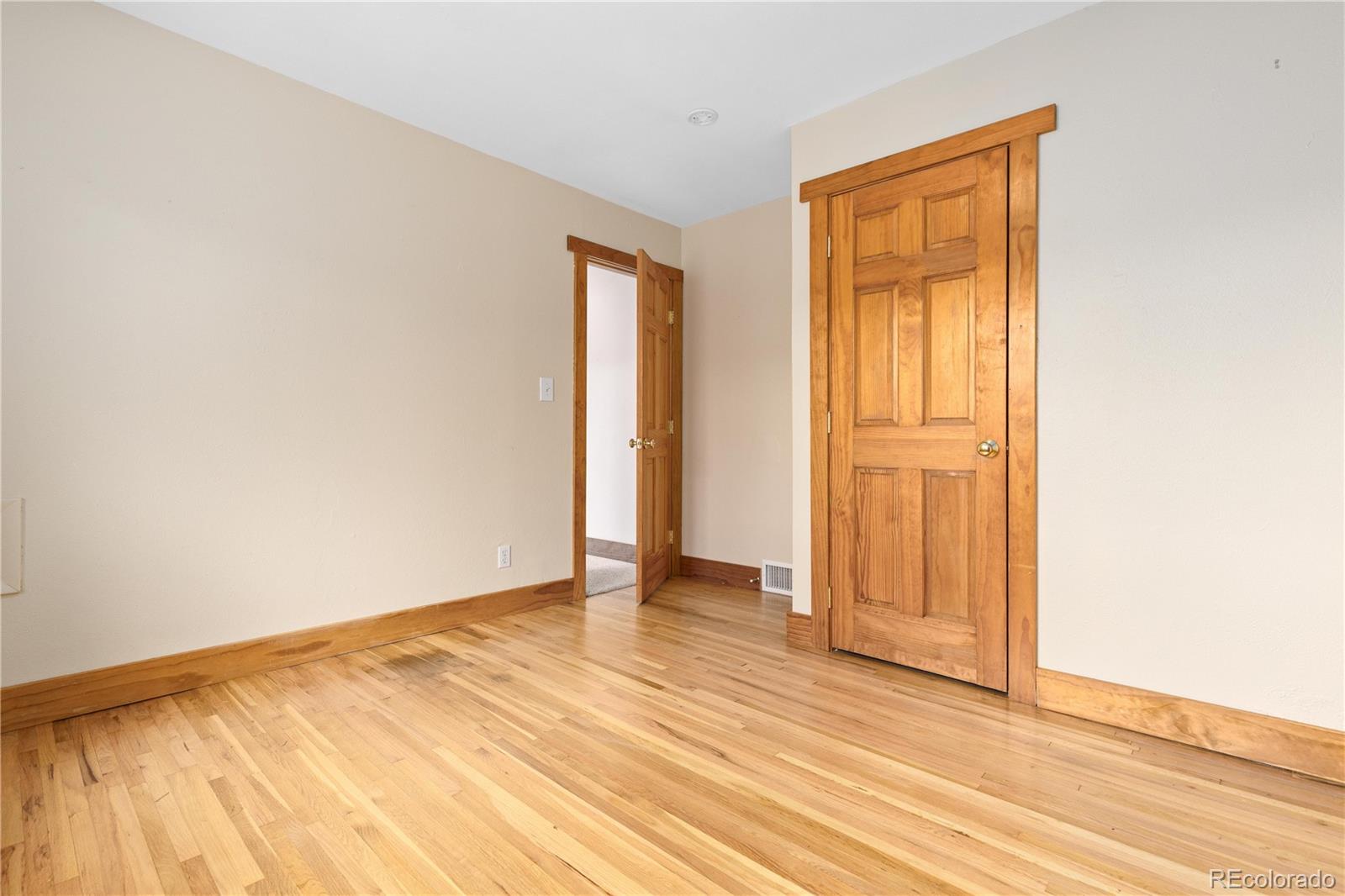 29723 Spruce Road Evergreen, CO 80439 - Photo 29 of 42 an empty room with wooden floor and closet area