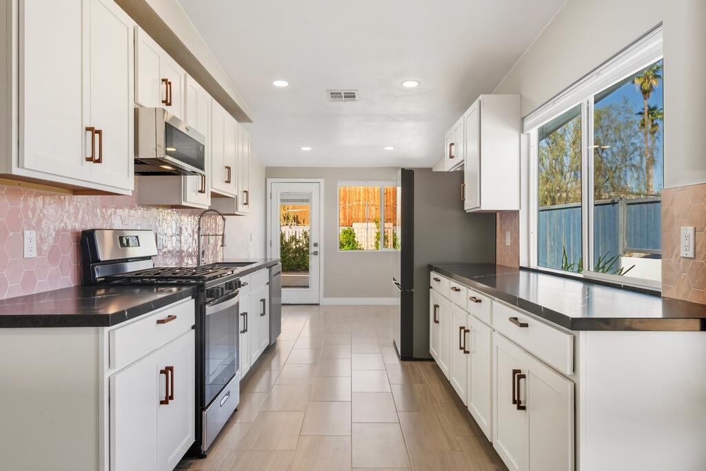 38855 Paradise Way Cathedral City, CA 92234 - Photo 12 of 67 a large kitchen with stainless steel appliances granite countertop a stove a sink and a granite counter tops