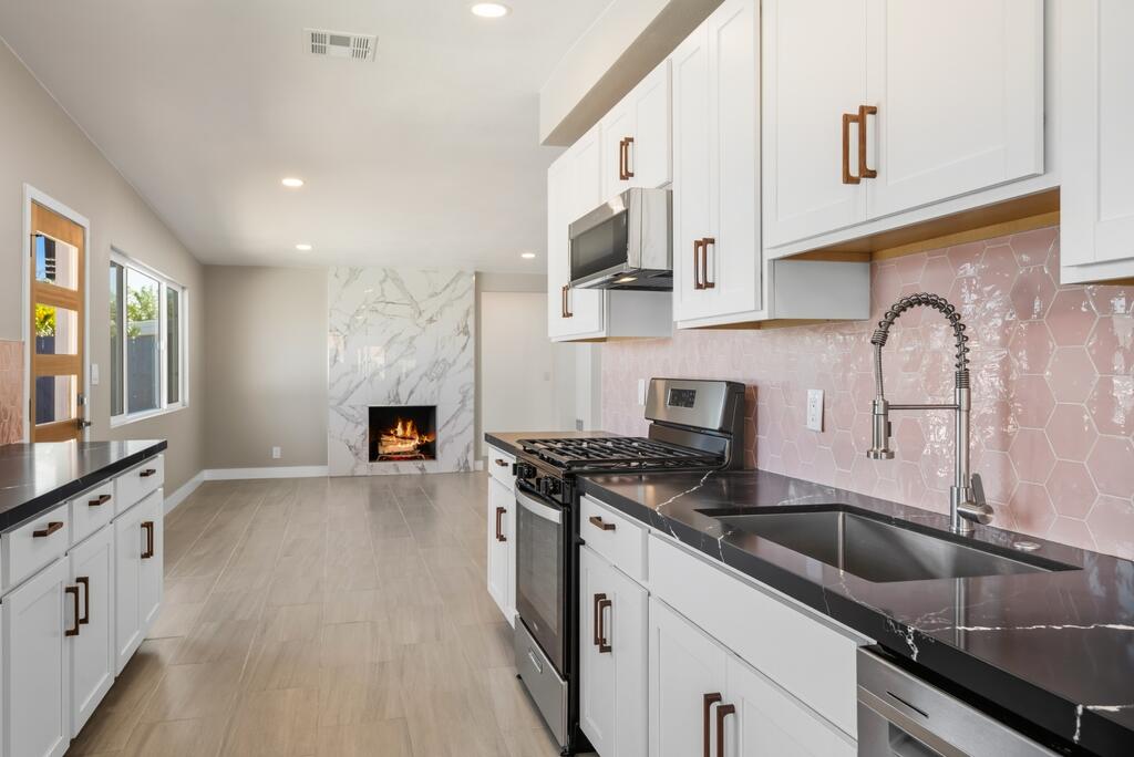 38855 Paradise Way Cathedral City, CA 92234 - Photo 14 of 67 a kitchen with stainless steel appliances granite countertop a sink stove refrigerator and cabinets