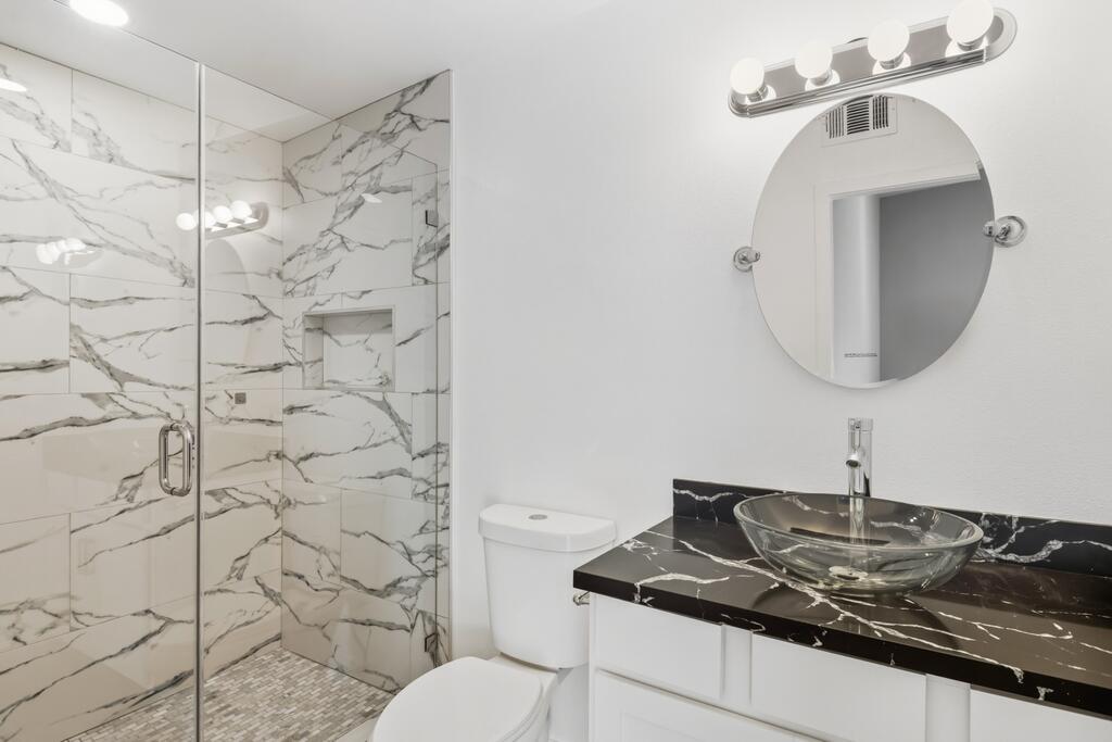 38855 Paradise Way Cathedral City, CA 92234 - Photo 23 of 67 a bathroom with a granite countertop sink a toilet and shower