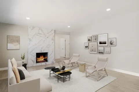 an empty room with windows a fireplace and wooden floor