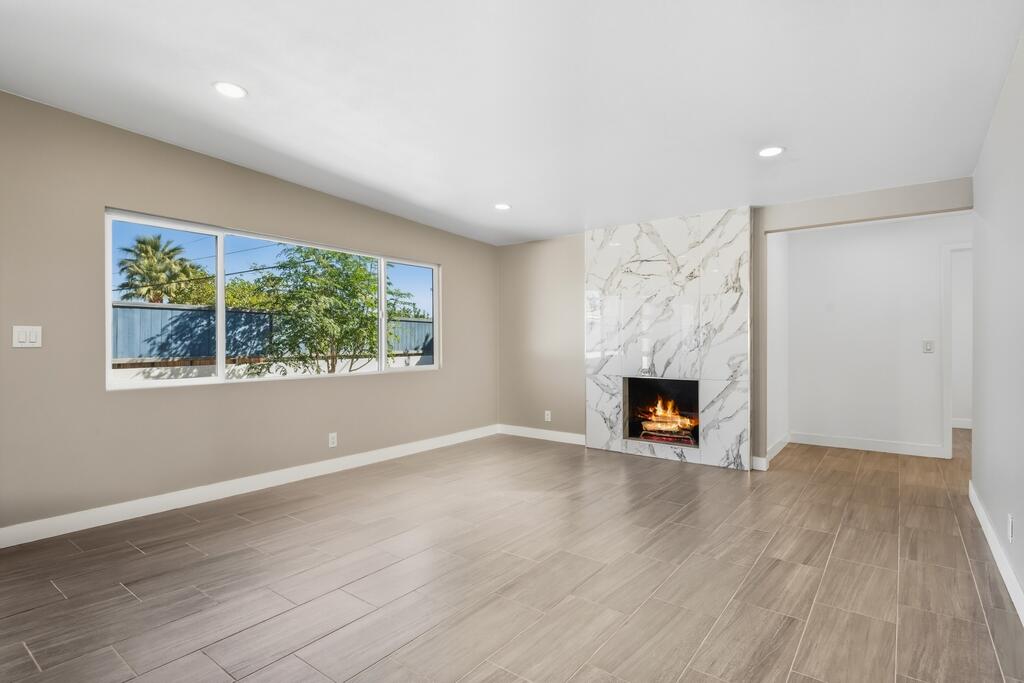 38855 Paradise Way Cathedral City, CA 92234 - Photo 9 of 67 an empty room with windows a fireplace and wooden floor