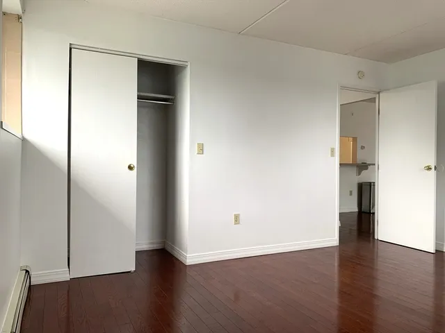 an empty room with wooden floor and closet