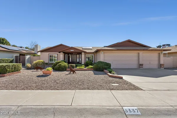 a front view of a house with yard and parking