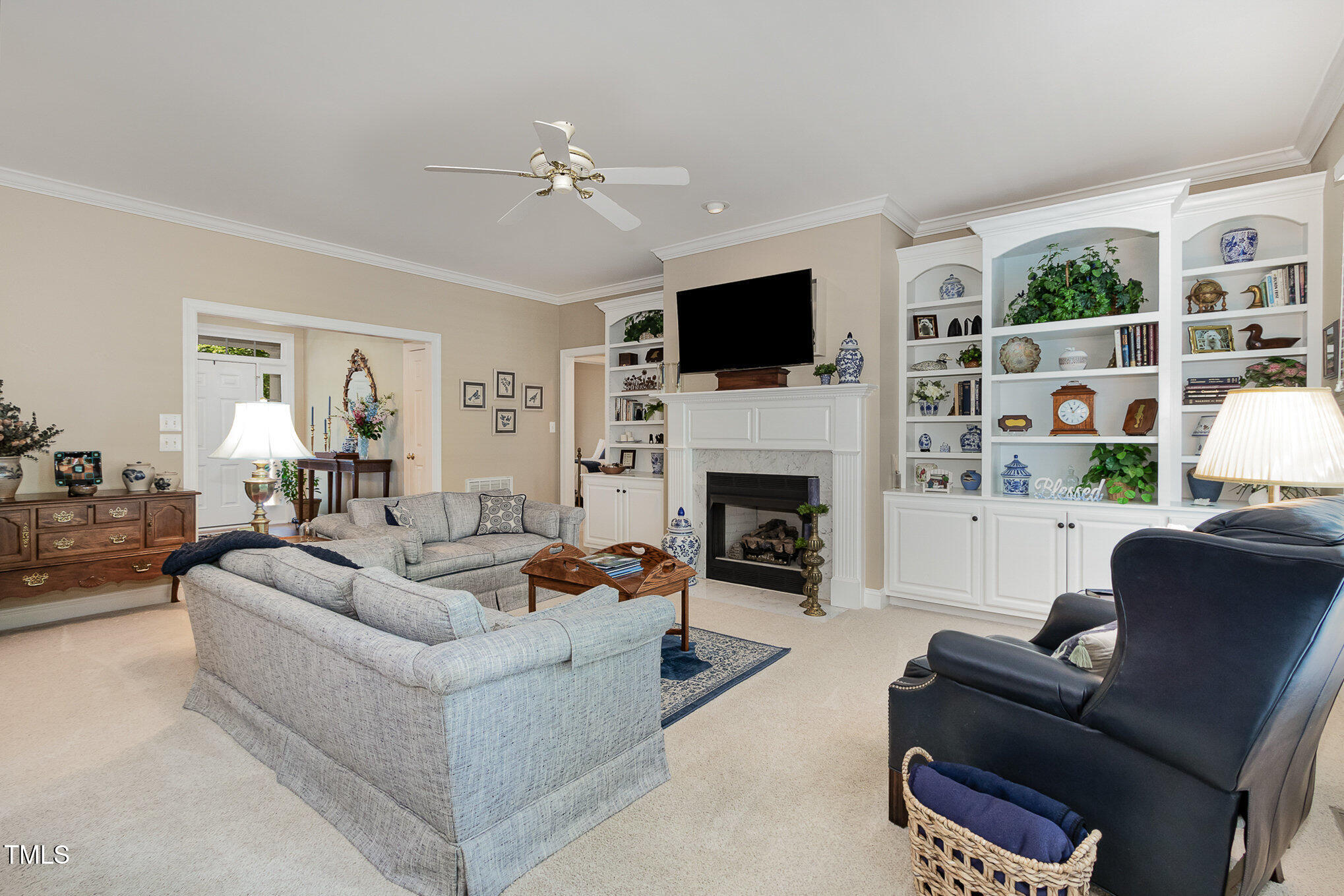 8304 Epping Forest Way Wake Forest, NC 27587 - Photo 9 of 41 a living room with furniture a fireplace and a flat screen tv
