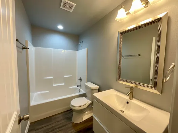 a bathroom with a sink and mirror with toilet