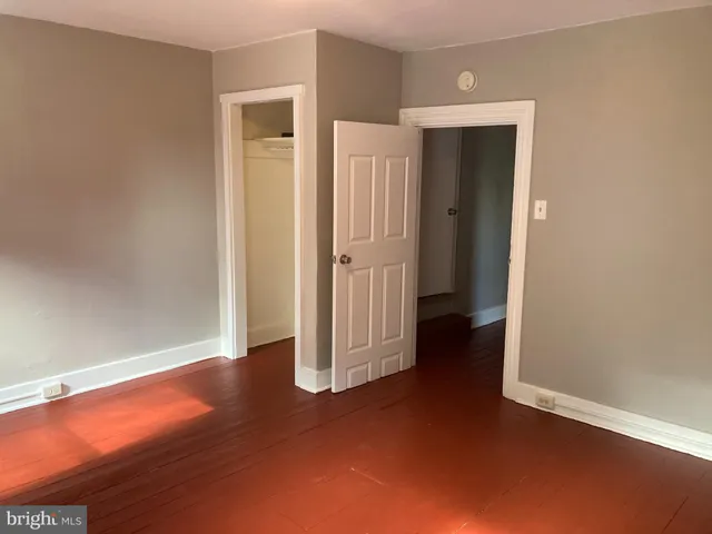 an empty room with closet and wooden floor