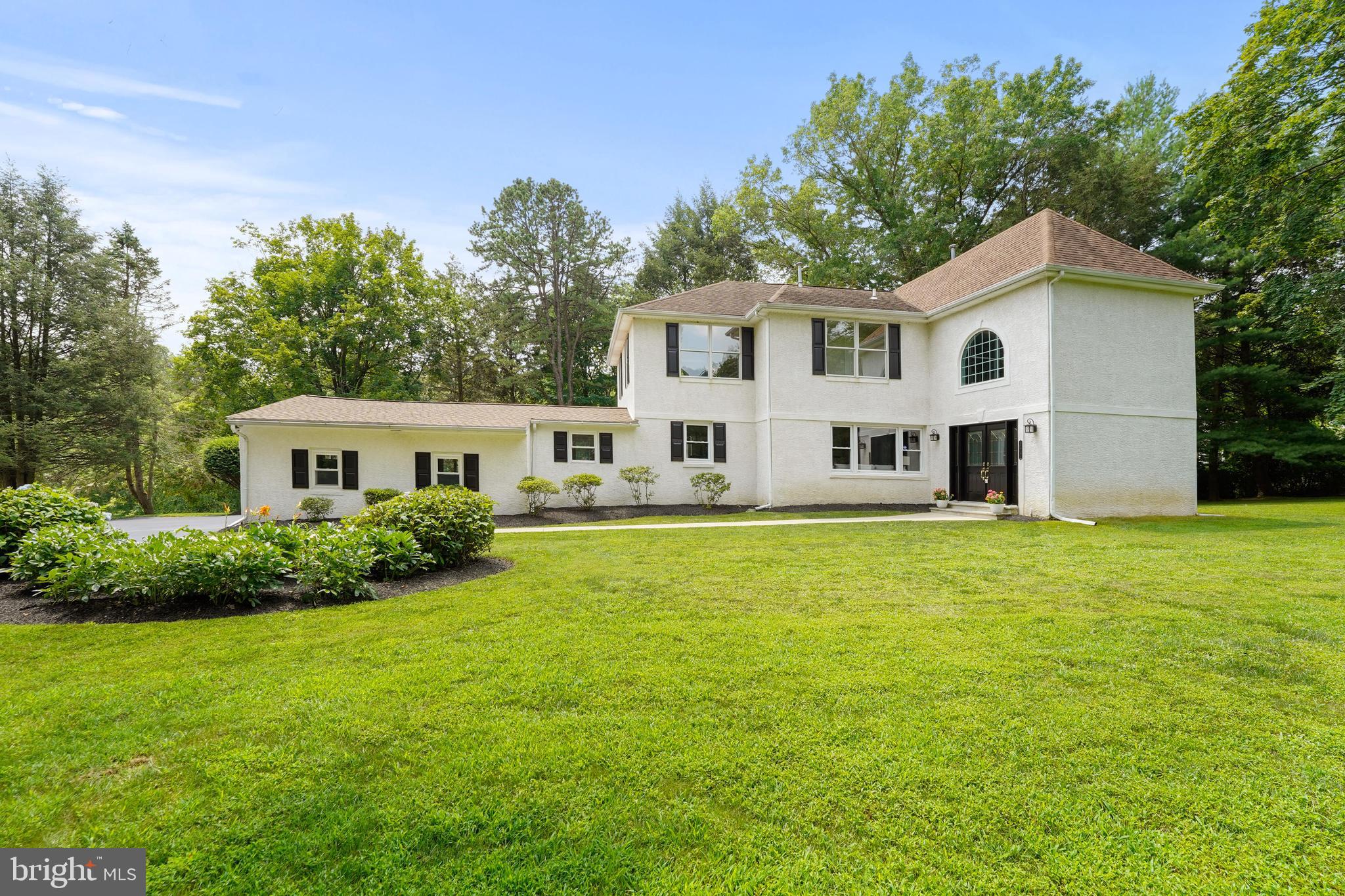 922 Hunt Road Radnor, PA 19008 - Photo 2 of 59 a view of a white house in front of a big yard with large trees