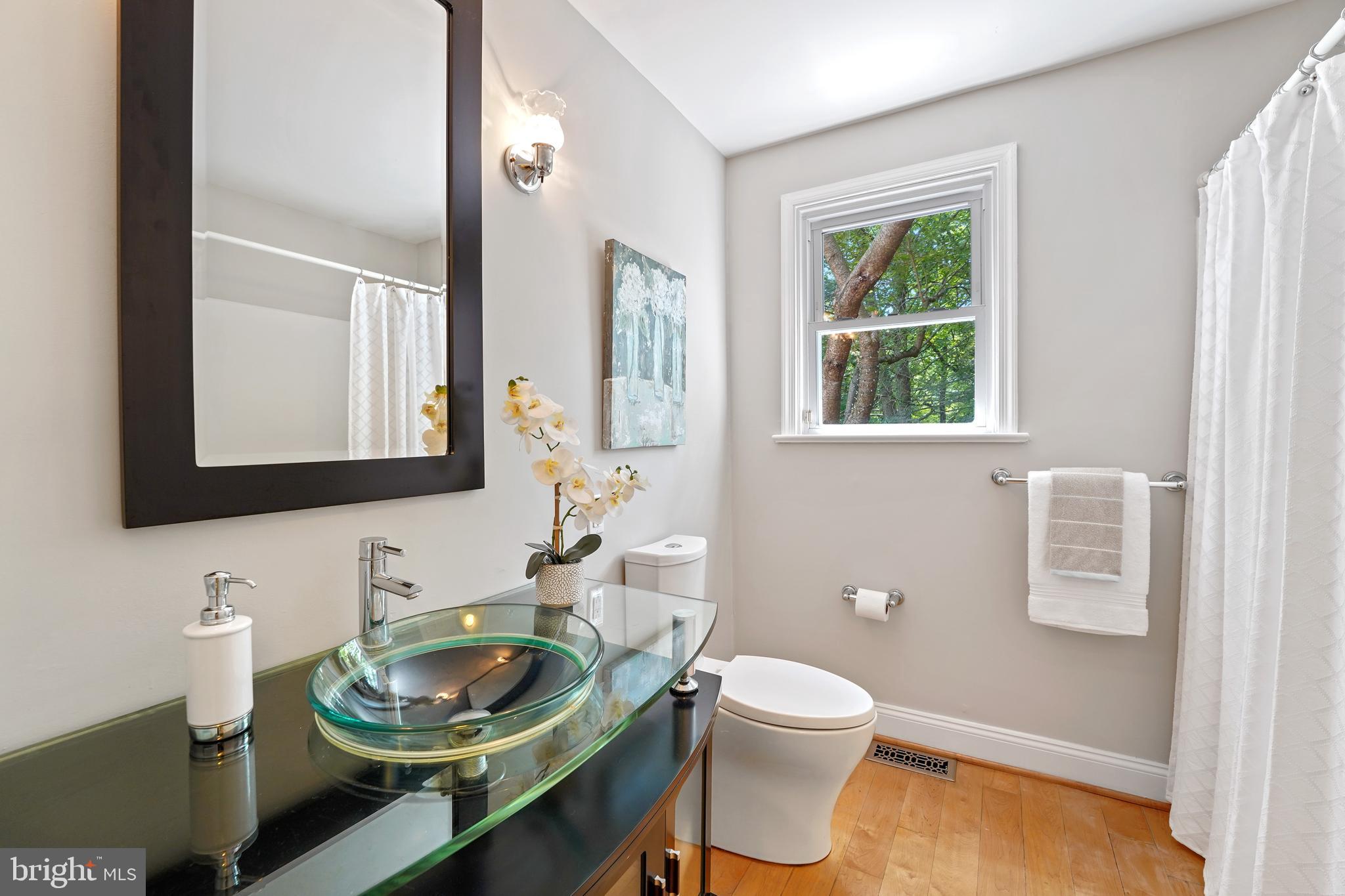 922 Hunt Road Radnor, PA 19008 - Photo 43 of 59 a bathroom with a granite countertop toilet a sink and a mirror