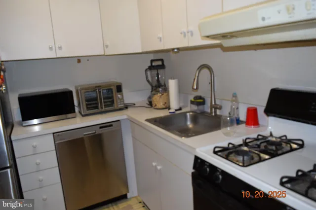 a kitchen with sink a stove and cabinets