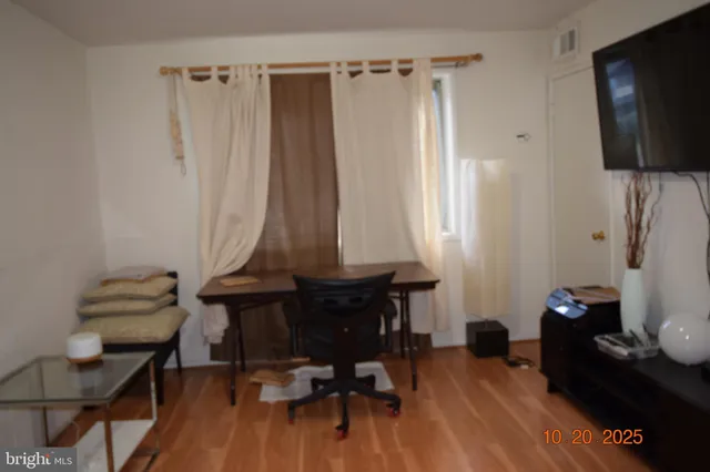 a view of a workspace with furniture and wooden floor