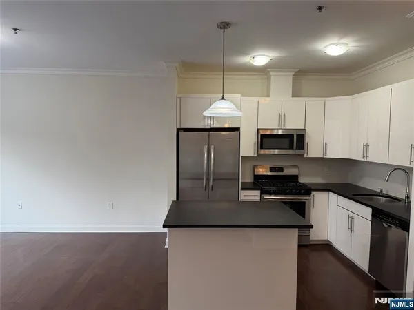 a kitchen with granite countertop a sink a stove and cabinets