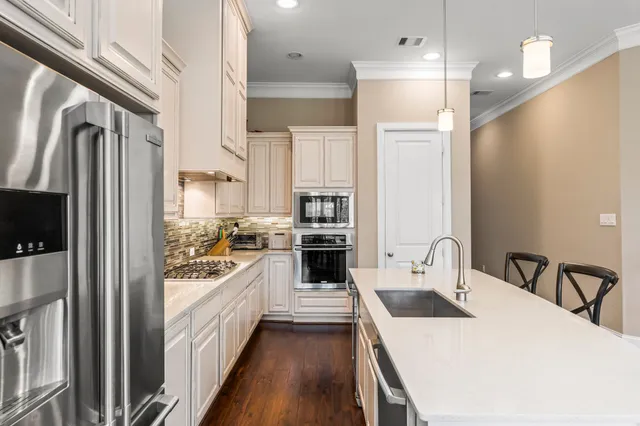 a kitchen with a sink a refrigerator and a stove top oven