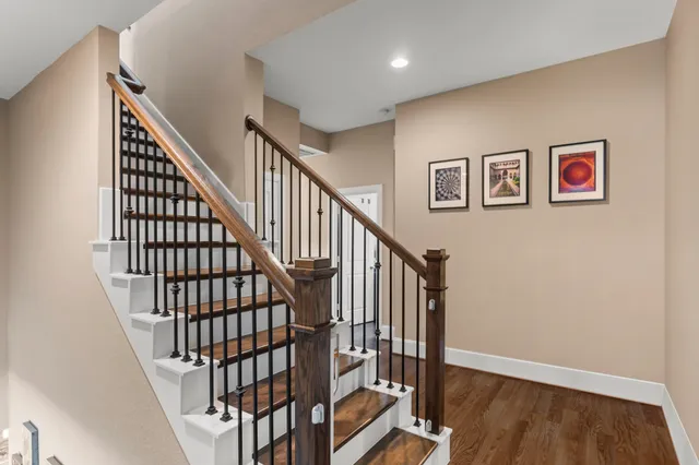 a view of staircase with wooden floor and white walls