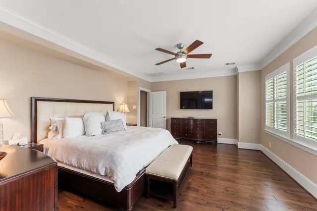 a bedroom with a large bed a flat tv screen and a night stand