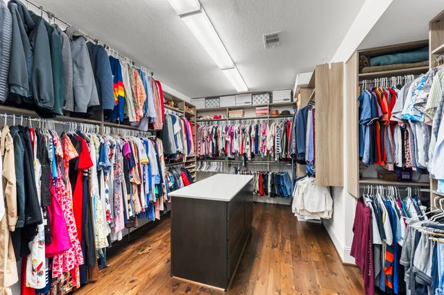 a view of walk in closet with clothes