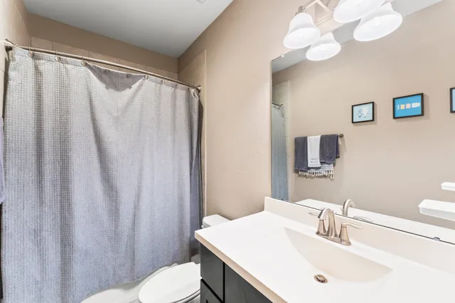 a bathroom with a sink vanity mirror and toilet